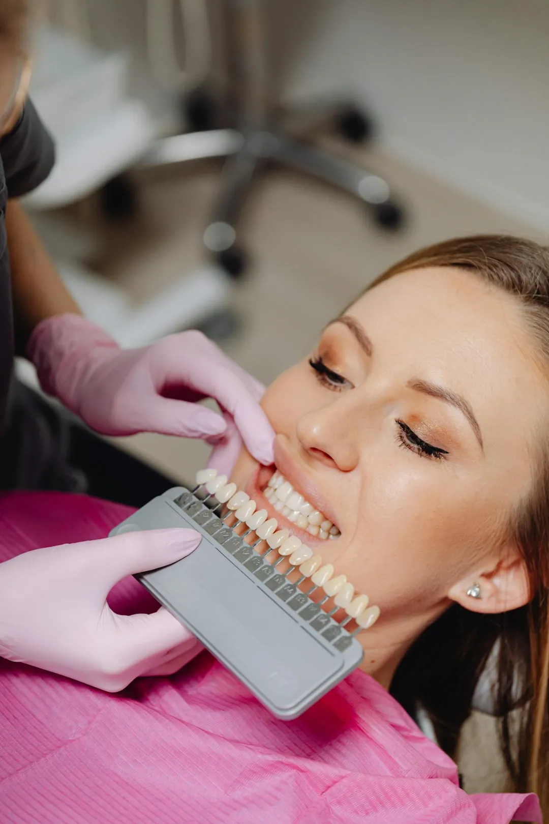 A Dentist Holding a Dental Shade Guide in front of a Patient